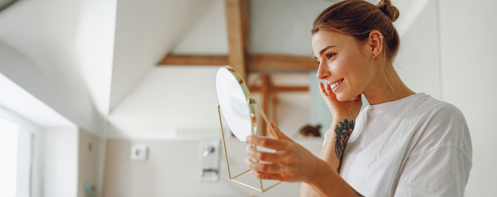 smiling-beautiful-lady-looking-at-her-face-in-a-sm-2024-10-18-08-12-11-utc (1)